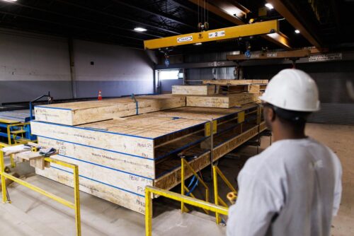 A-worker-observes-a-crane-moving-floor-panels_med-500x334.jpg